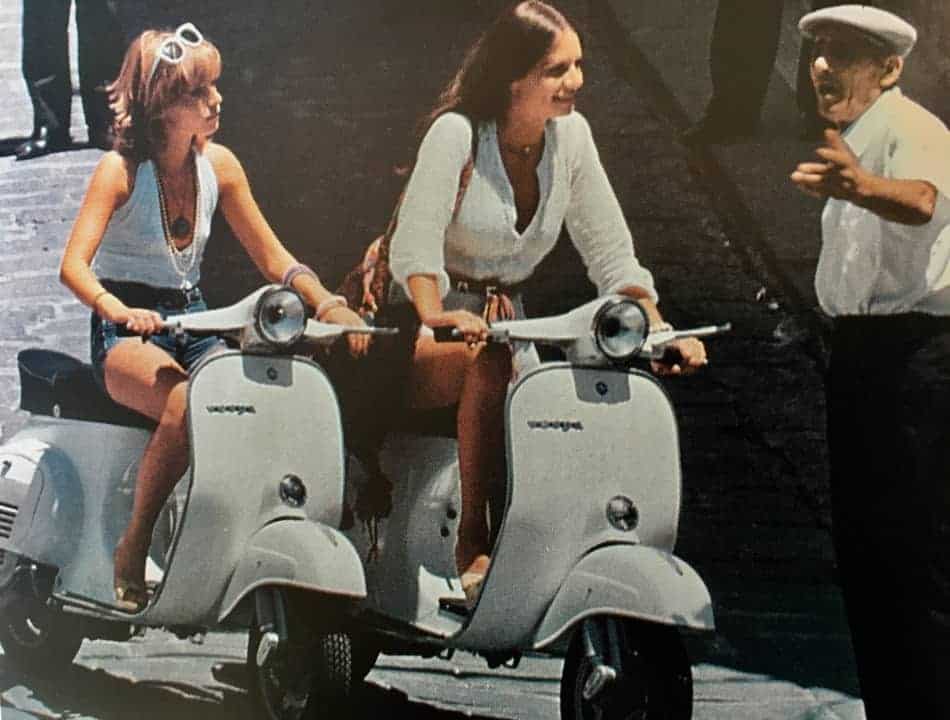 Italian teenagers driving a vespa 