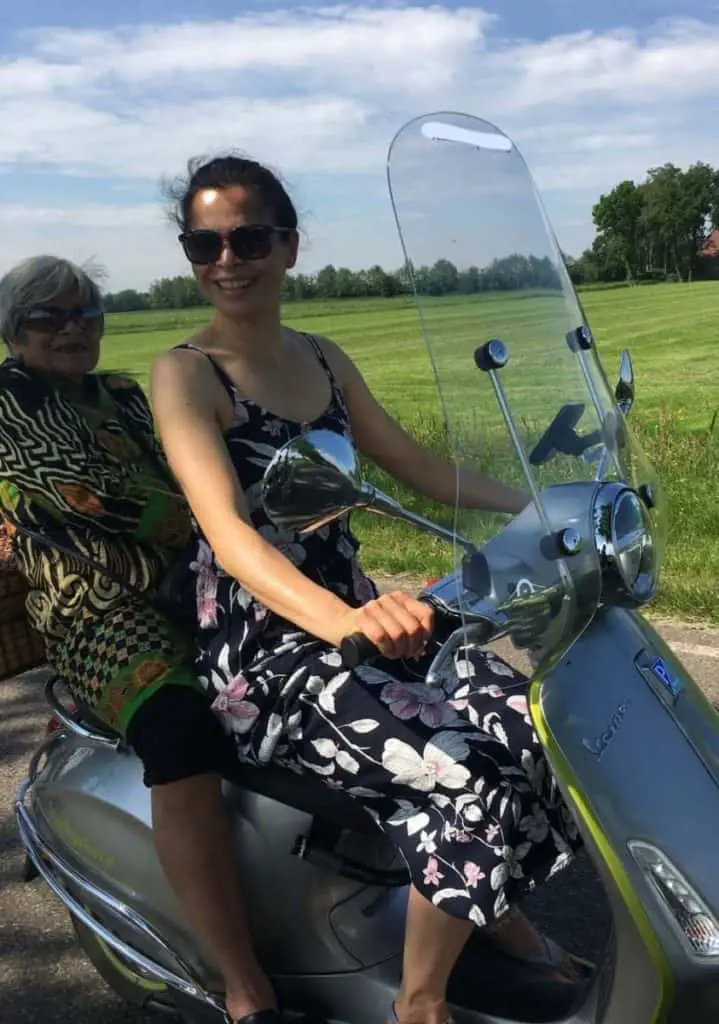 driving a Vespa with a passenger