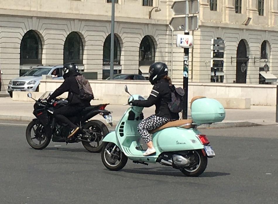 lady driving a mint large frame modern vespa
