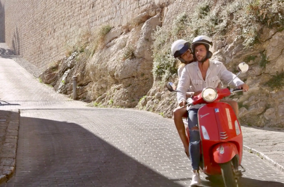 couple driving a vespa wearing a open face helmet