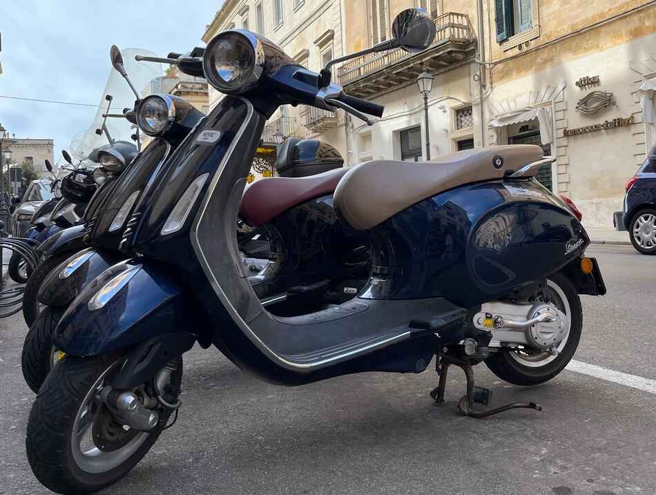 Neatly parked vespa primavera in italy