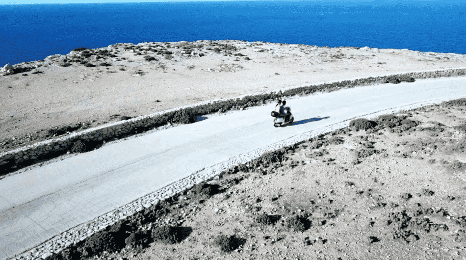 couple driving a vespa in sicily